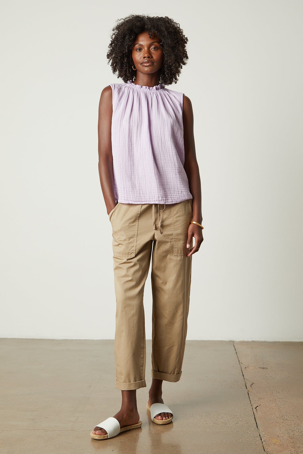 the model is wearing a Velvet by Graham & Spencer BIANCA COTTON GAUZE TANK TOP and khaki pants.-26317127352513