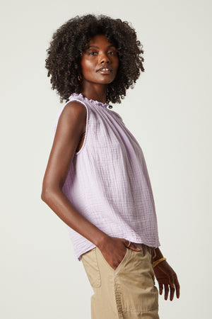 A black woman wearing a Velvet by Graham & Spencer BIANCA COTTON GAUZE TANK TOP and tan pants.
