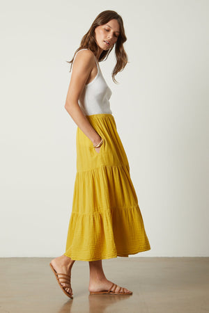 a woman wearing a yellow Danielle Cotton Gauze Tiered Skirt by Velvet by Graham & Spencer.