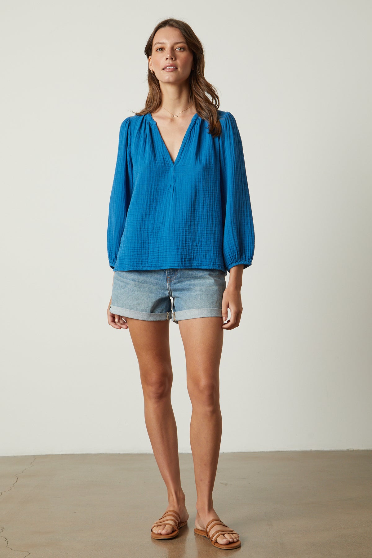   the model is wearing Velvet by Graham & Spencer denim shorts and a Velvet by Graham & Spencer blue blouse. 