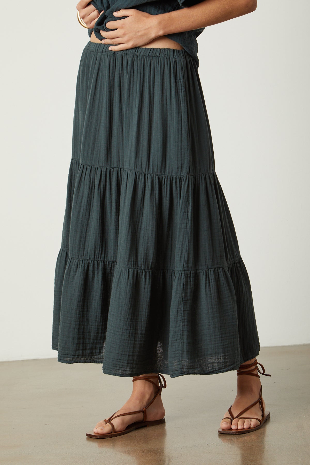   A woman wearing a Velvet by Graham & Spencer Danielle Cotton Gauze Tiered Skirt and sandals. 