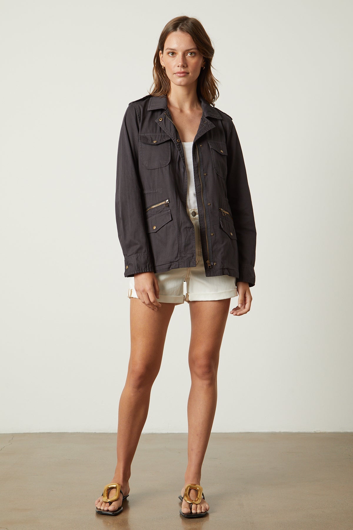  A woman wearing a Velvet by Graham & Spencer RUBY LIGHT-WEIGHT ARMY JACKET and shorts. 