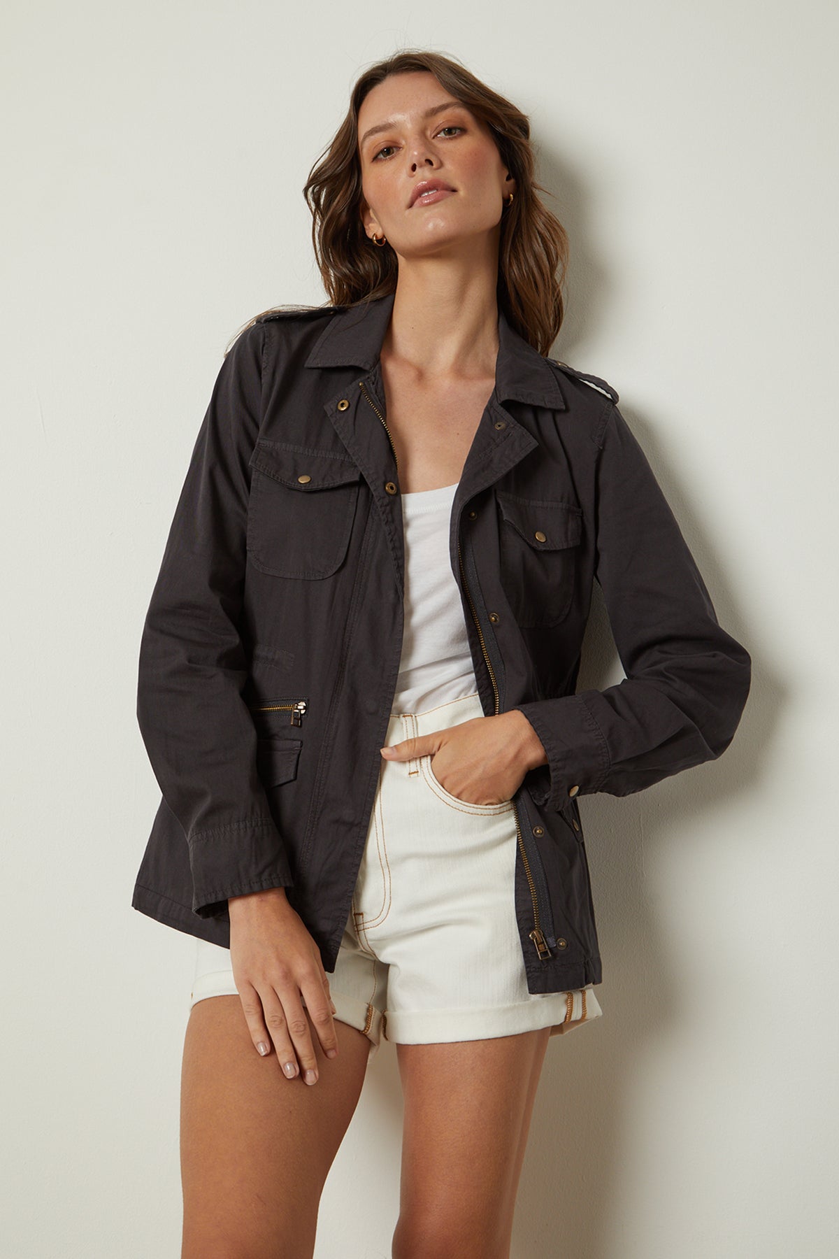 The model is wearing a Velvet by Graham & Spencer RUBY LIGHT-WEIGHT ARMY JACKET and white shorts.-26632087929025