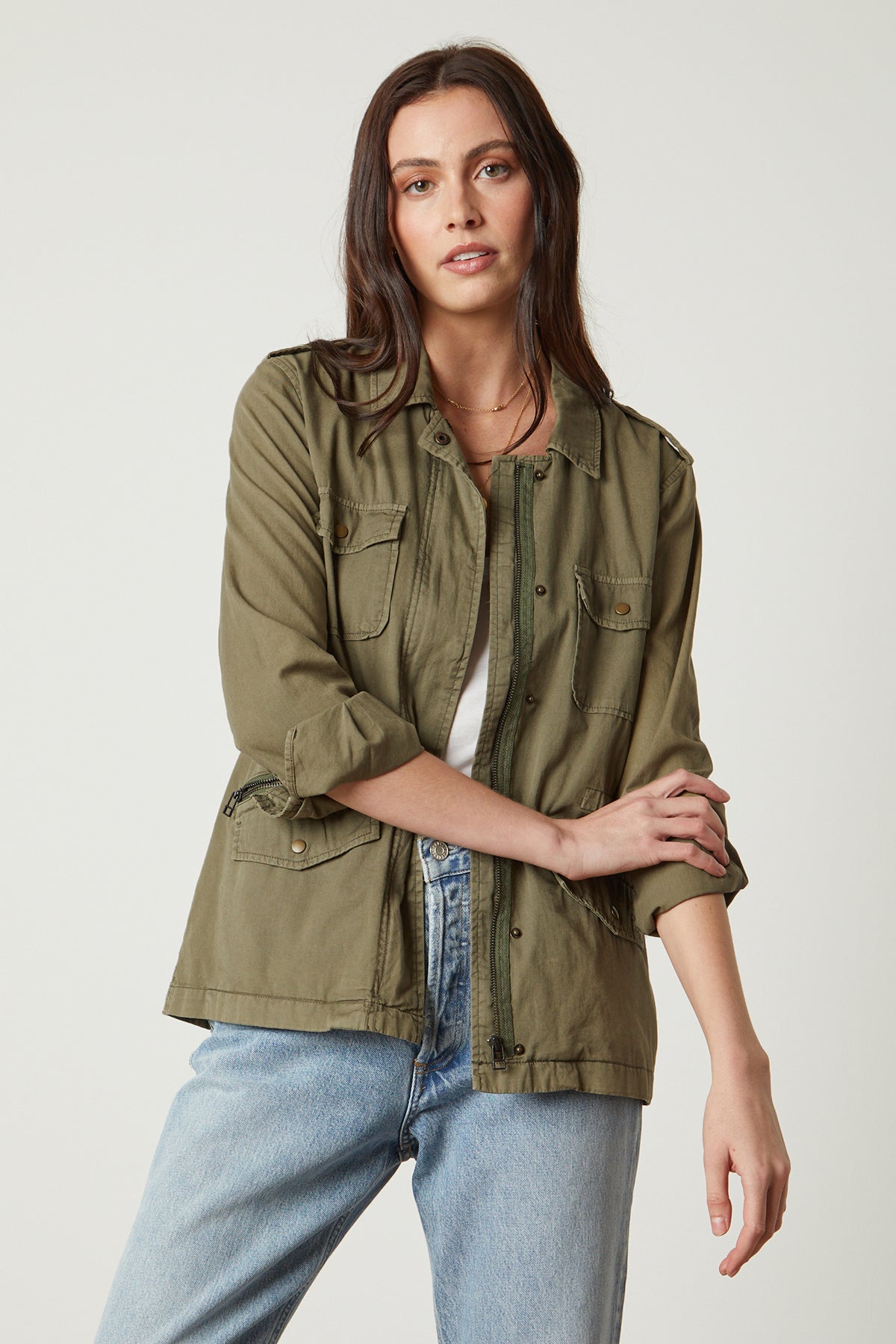   A woman wearing a RUBY LIGHT-WEIGHT ARMY JACKET, made by Velvet by Graham & Spencer, and jeans. 