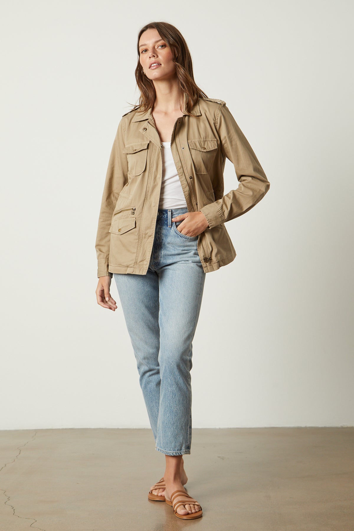 The woman is wearing jeans and a Velvet by Graham & Spencer RUBY LIGHT-WEIGHT ARMY JACKET.-26632088715457