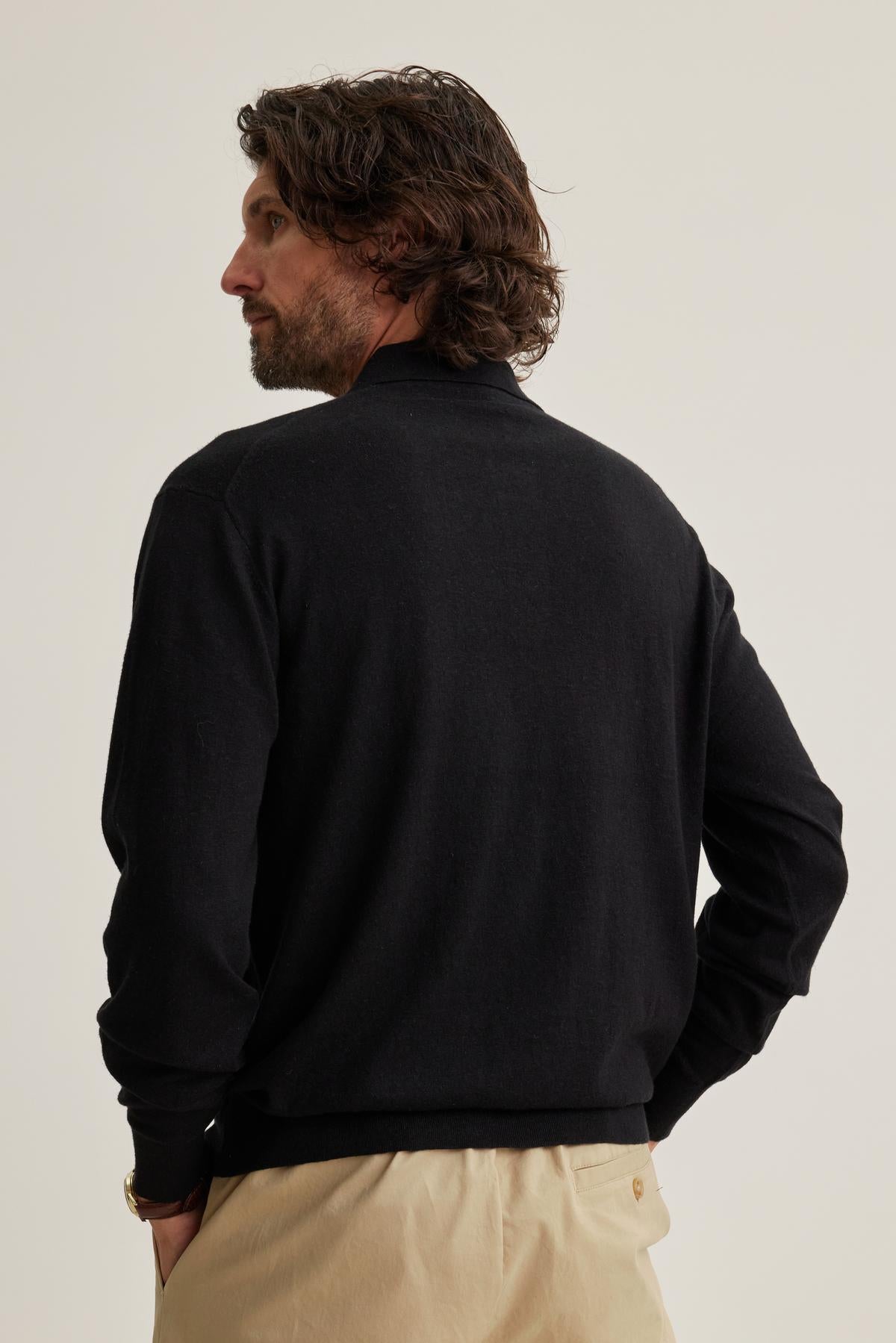 A man with wavy hair is wearing a Velvet by Graham & Spencer MATTEO Cotton Linen Sweater Polo and beige pants, facing away against a plain background.-38643324747969