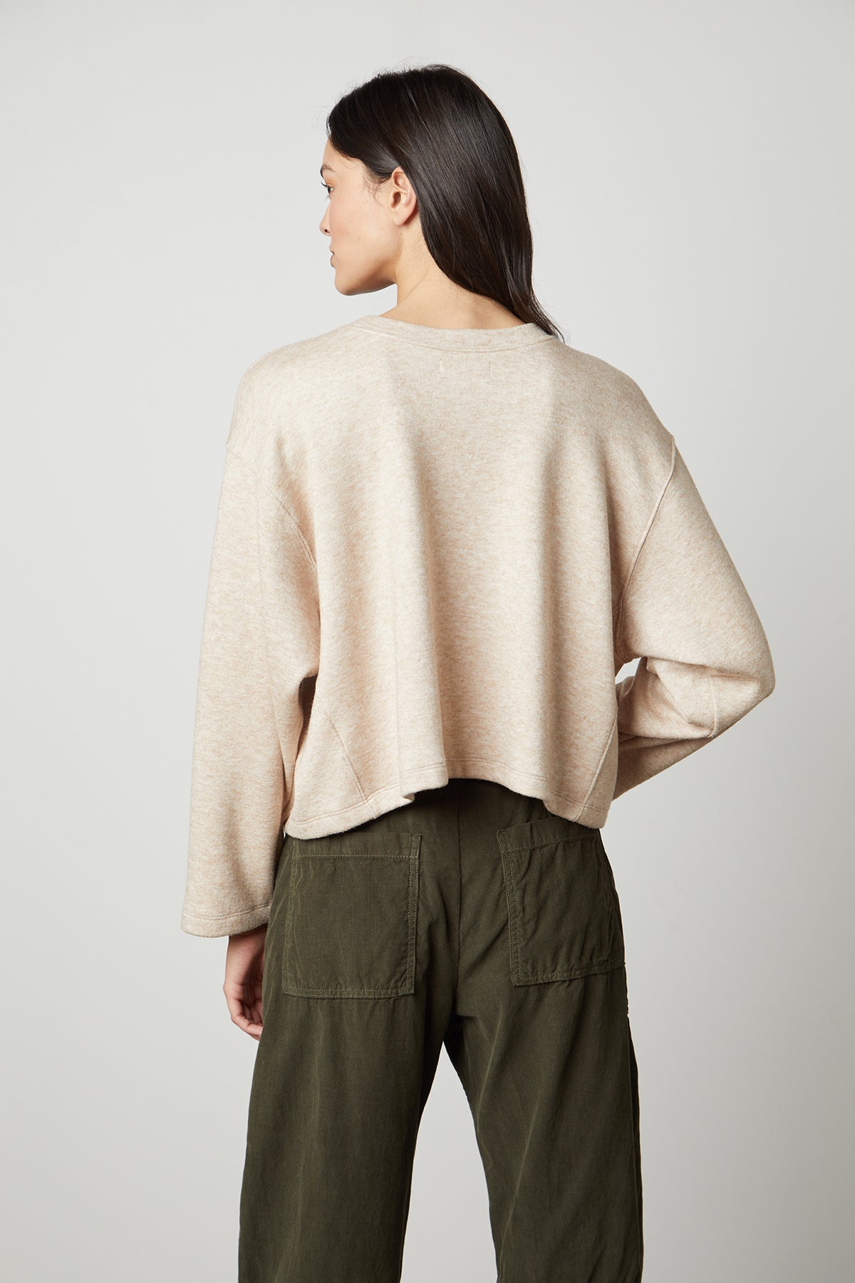 The back view of a woman wearing an oversized beige NIA DOUBLE KNIT CROPPED CREW sweater and olive pants, exuding style and comfort. (Brand Name: Velvet by Graham & Spencer)-35503558918337