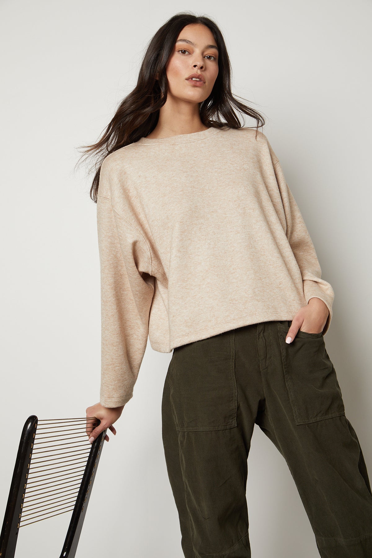   The model is wearing an oversized NIA DOUBLE KNIT CROPPED CREW sweater by Velvet by Graham & Spencer and olive trousers, combining comfort and style. 