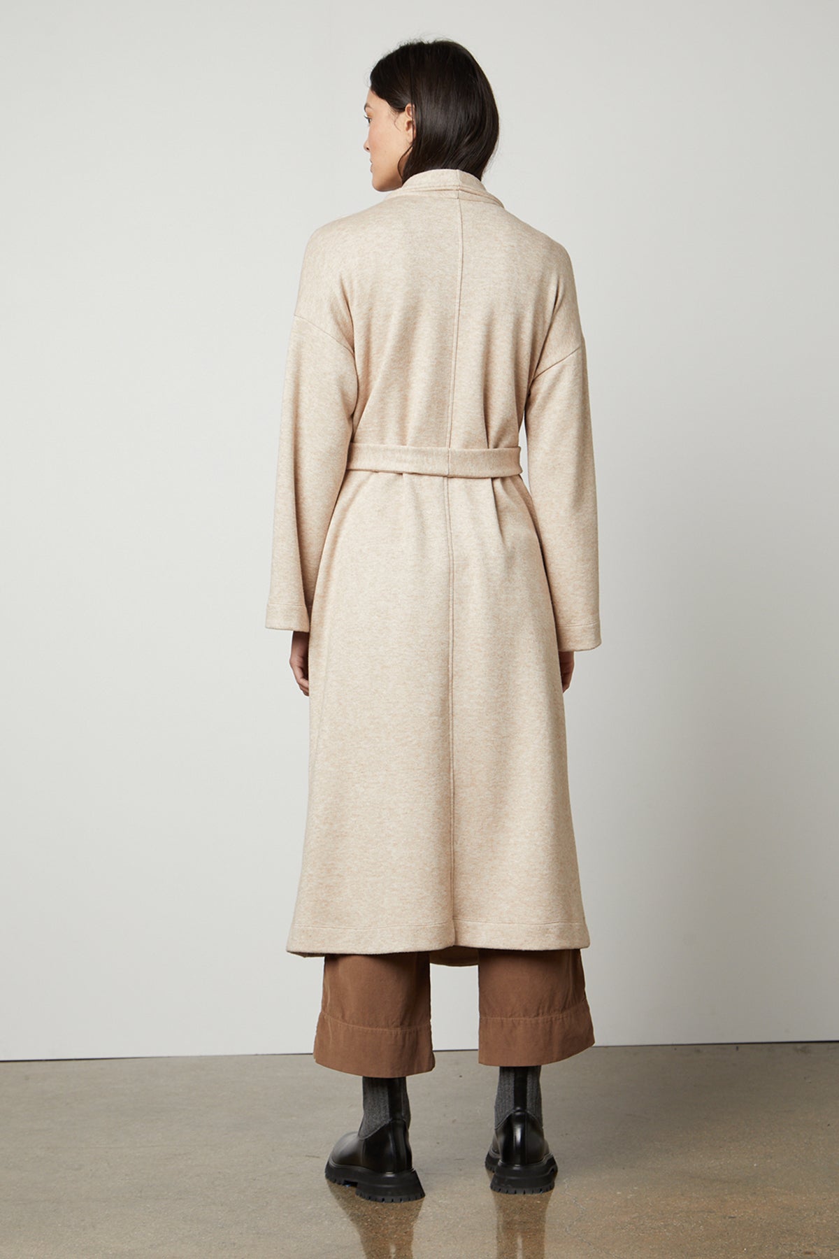 The back view of a woman wearing a Velvet by Graham & Spencer PATRICIA DOUBLE KNIT DUSTER CARDIGAN, a cozy layering piece in beige fabric.-35503542141121