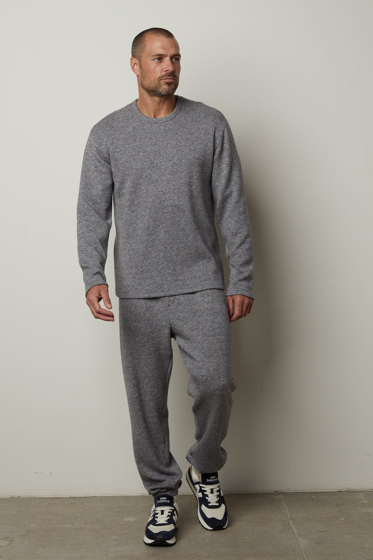   A man wearing SALINGER DOUBLE KNIT SWEATPANTS by Velvet by Graham & Spencer and sneakers. 