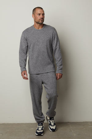 A man wearing SALINGER DOUBLE KNIT SWEATPANTS by Velvet by Graham & Spencer and sneakers.