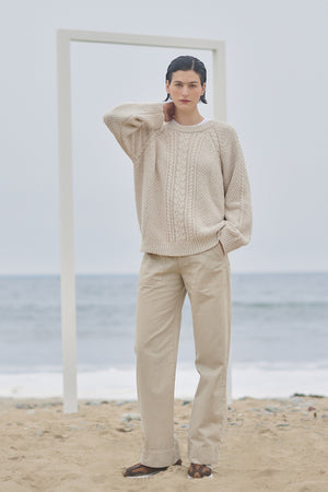 A woman is standing on the beach wearing Velvet by Jenny Graham VENTURA PANT sweater and trousers.