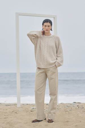 A woman standing on the beach wearing a HERMOSA SWEATER by Velvet by Jenny Graham.