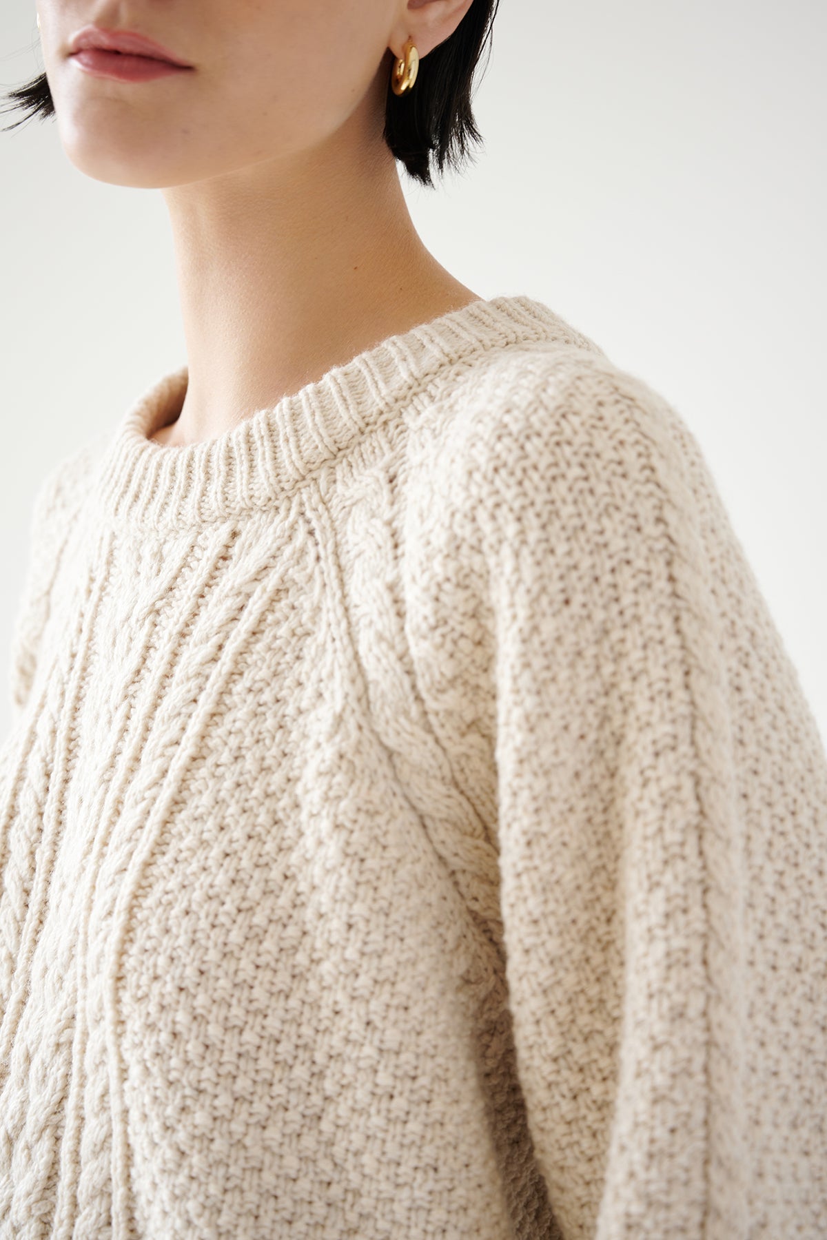 A woman donning a cream HERMOSA SWEATER by Velvet by Jenny Graham, perfect for her cold-weather wardrobe.-35547403256001