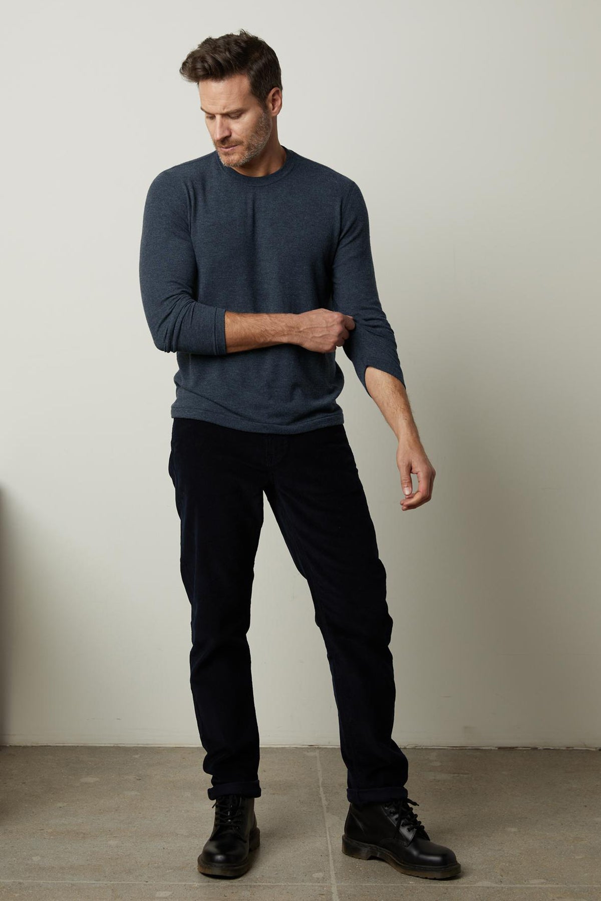   A man wearing the Velvet by Graham & Spencer BECKER COZY JERSEY CREW blue sweater and black pants. 