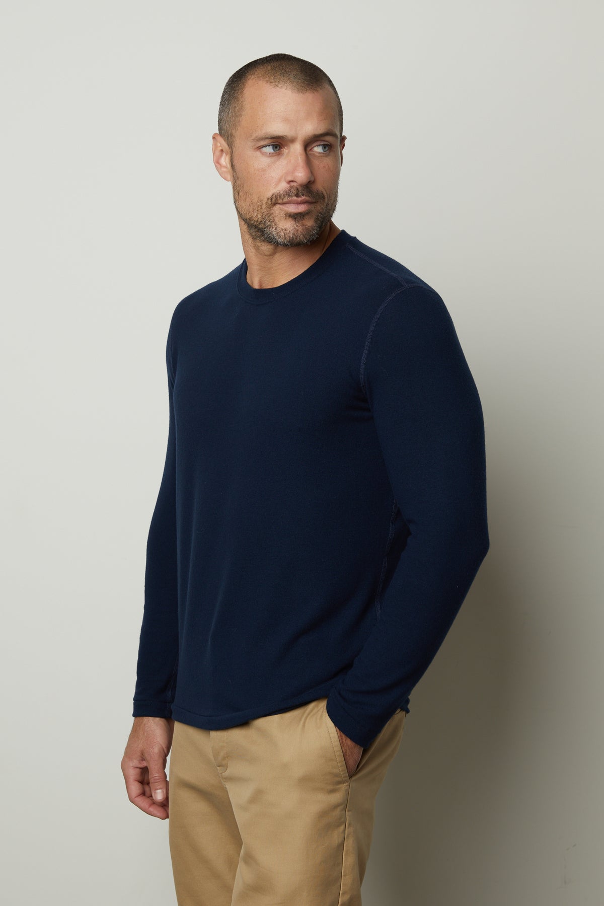   A man wearing a Velvet by Graham & Spencer BECKER COZY JERSEY CREW navy long sleeved tee and khaki pants. 