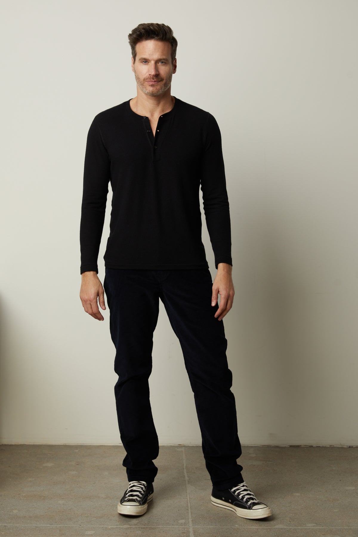  A cozy man wearing a black Velvet by Graham & Spencer Ryland Henley shirt. 