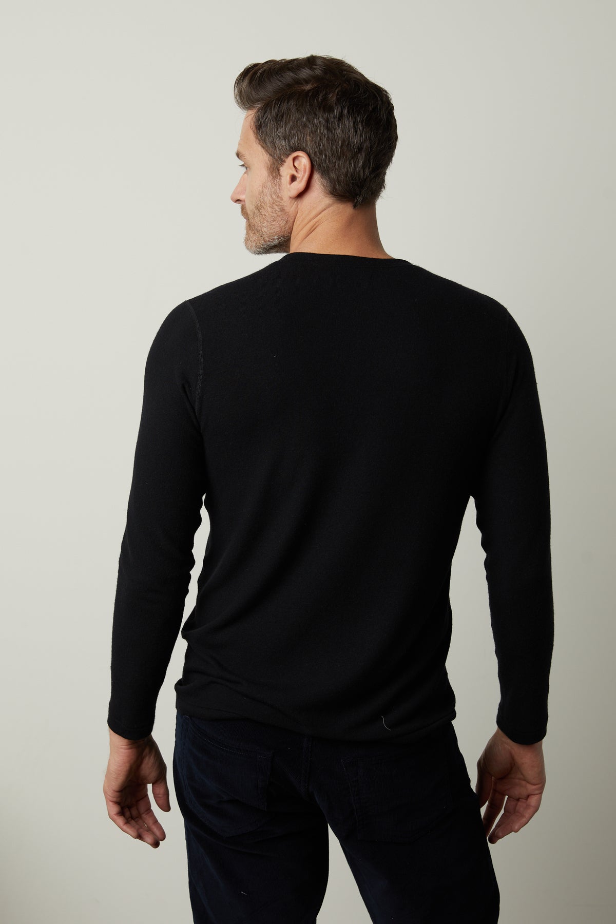   The back view of a man wearing a Velvet by Graham & Spencer RYLAND HENLEY made with a cozy jersey fabrication. 