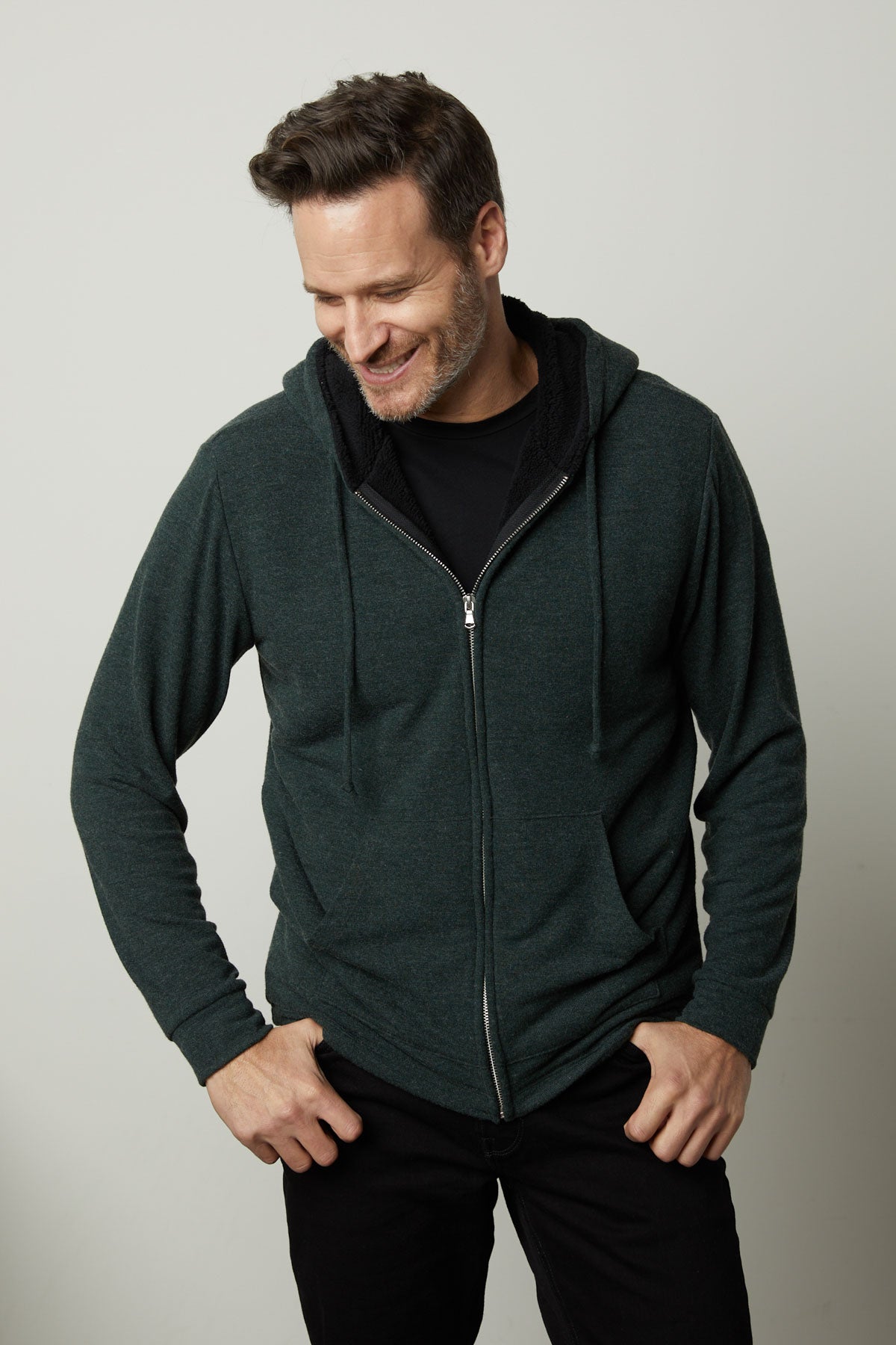   A man wearing a Velvet by Graham & Spencer SALVADORE SHERPA LINED HOODIE with an adjustable drawstring hood. 