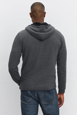 A person wearing the Velvet by Graham & Spencer SALVADORE HOODIE in dark gray, paired with blue jeans, is seen from the back, standing against a plain light background.