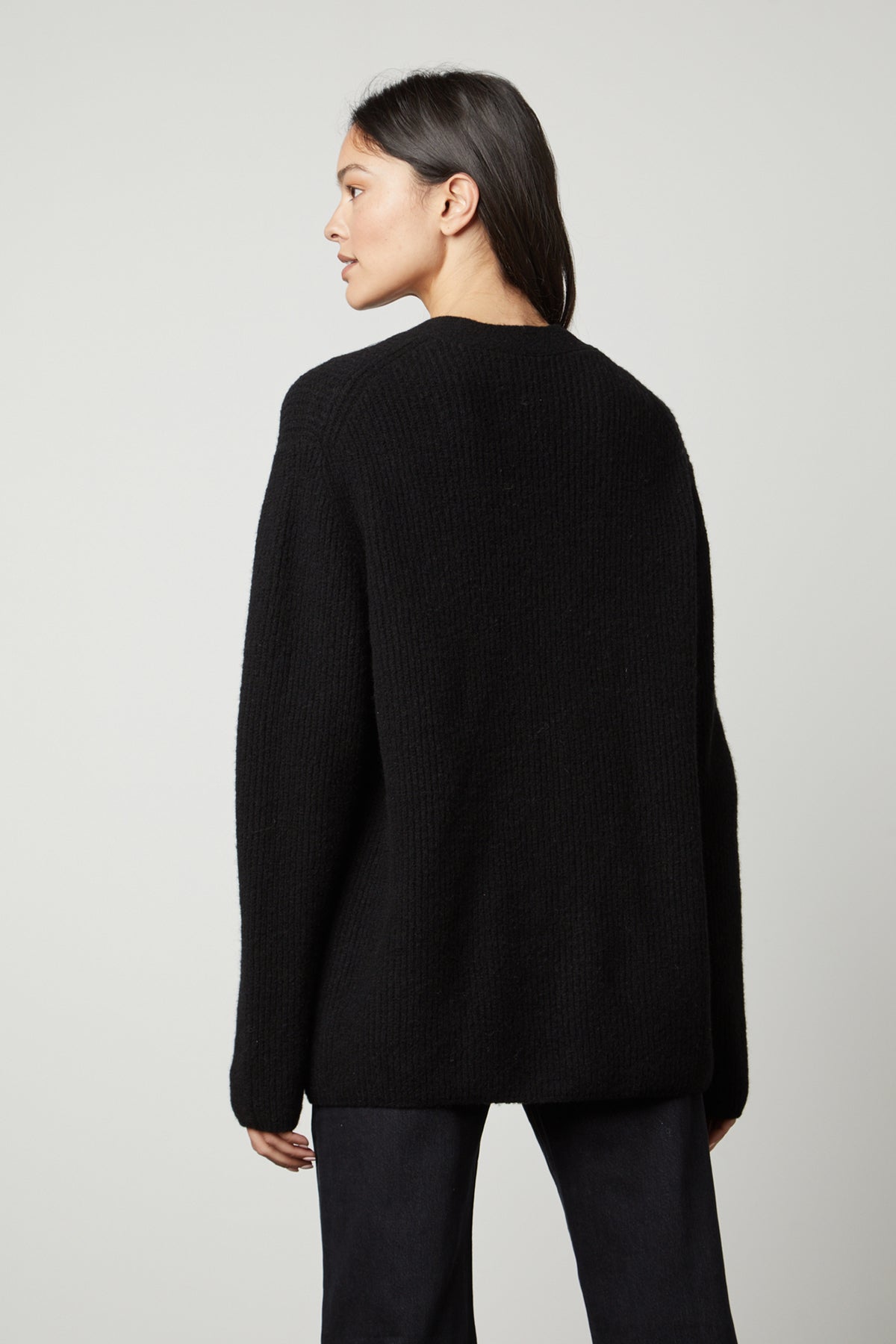   The back view of a woman wearing the BRITT OVERSIZED CARDIGAN from Velvet by Graham & Spencer. 