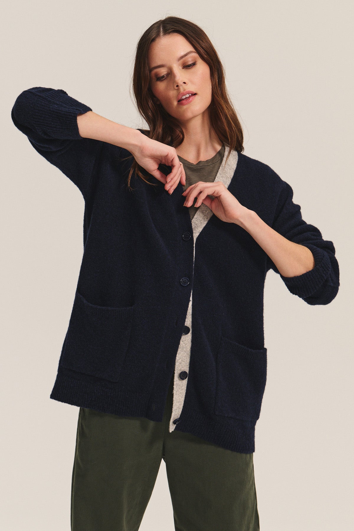 A woman poses for a photo in the Velvet by Graham & Spencer CAMERON CARDIGAN, a relaxed fit wool blend sweater featuring color-block stripes.