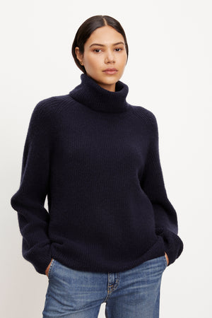 A model wearing a cozy Velvet by Graham & Spencer JUDITH turtleneck sweater.