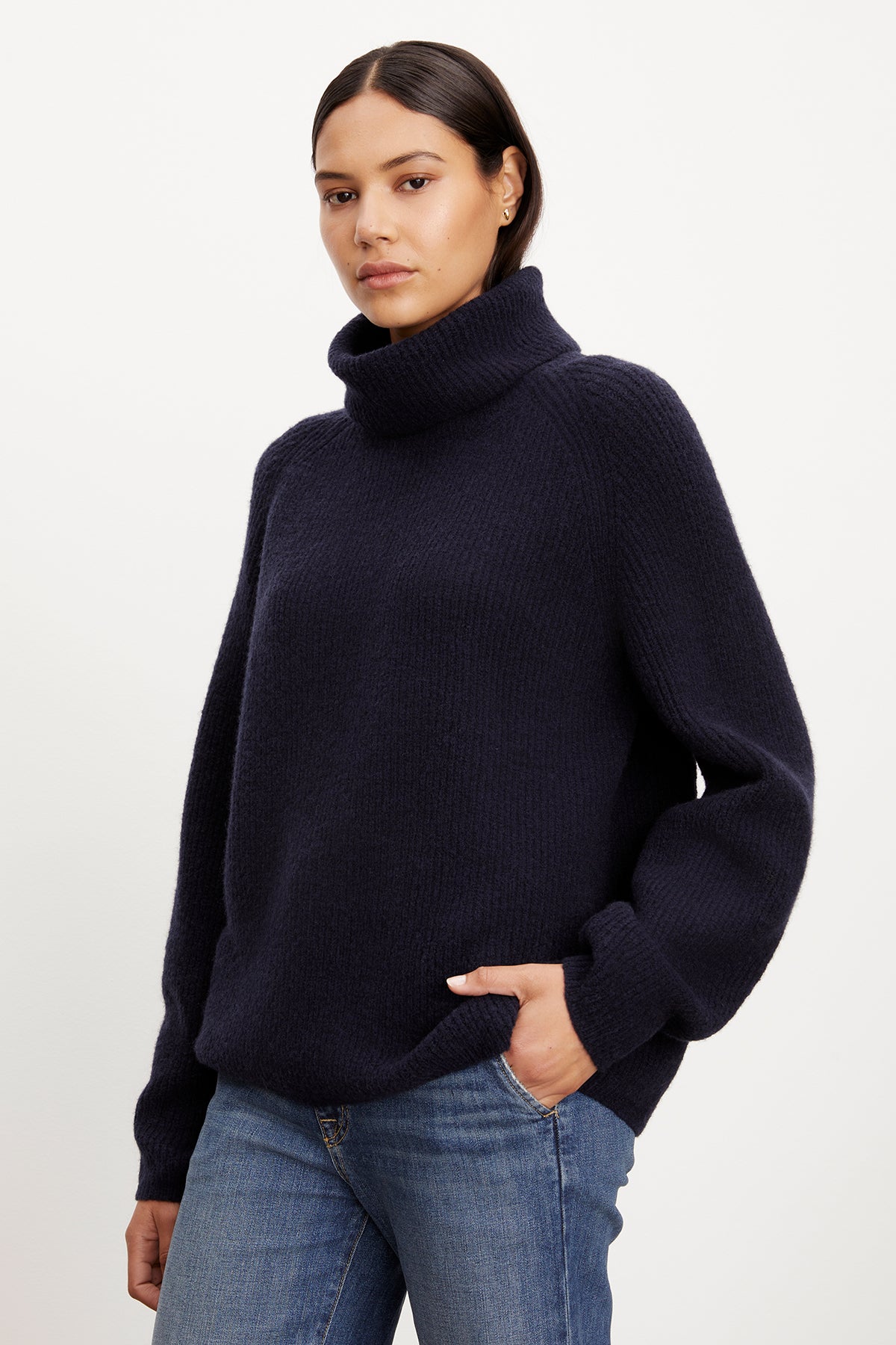   A model wearing a cozy Velvet by Graham & Spencer JUDITH turtleneck sweater and jeans. 