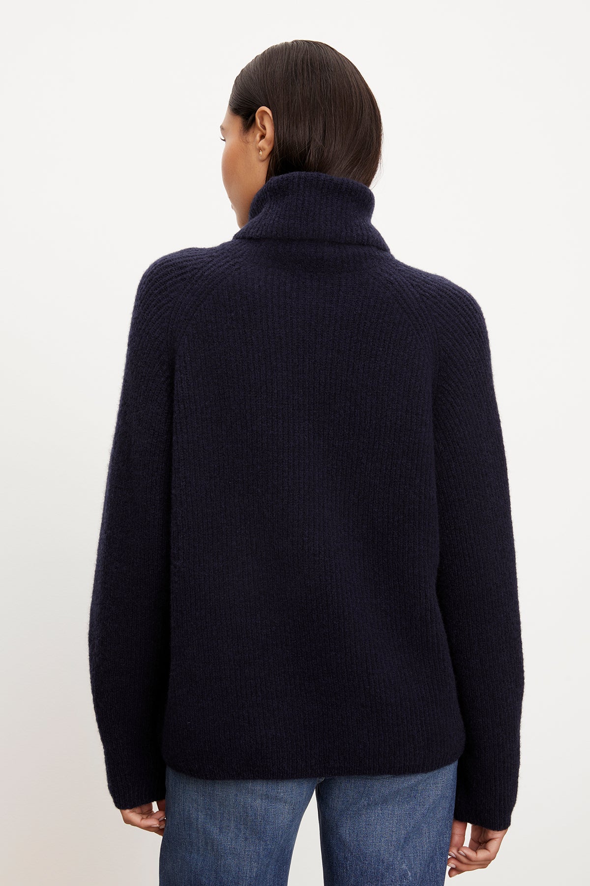   The woman wearing a Velvet by Graham & Spencer navy Judith turtleneck sweater exudes cozy dressing. 