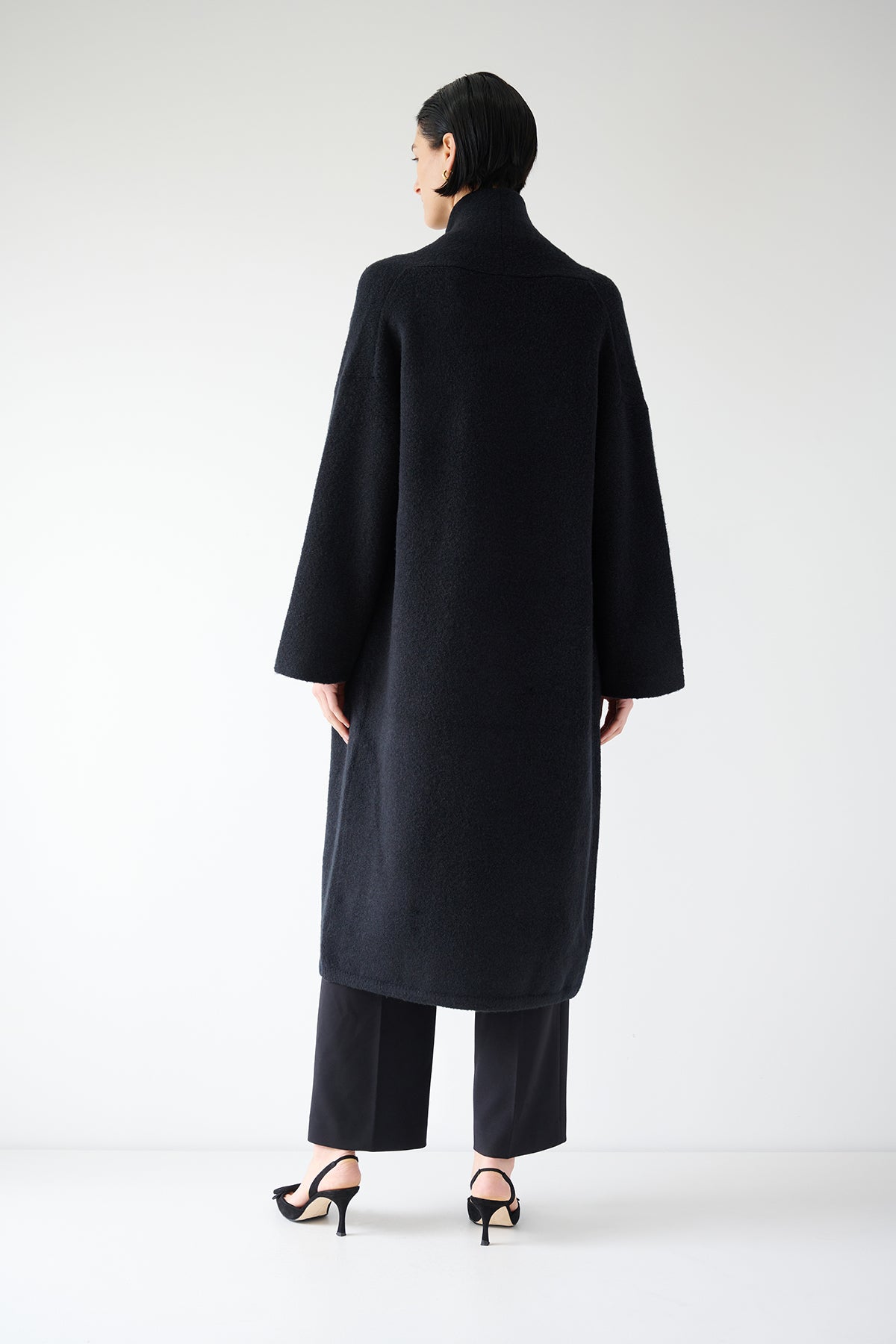   The back view of a woman wearing a CARMEL COAT by Velvet by Jenny Graham. 