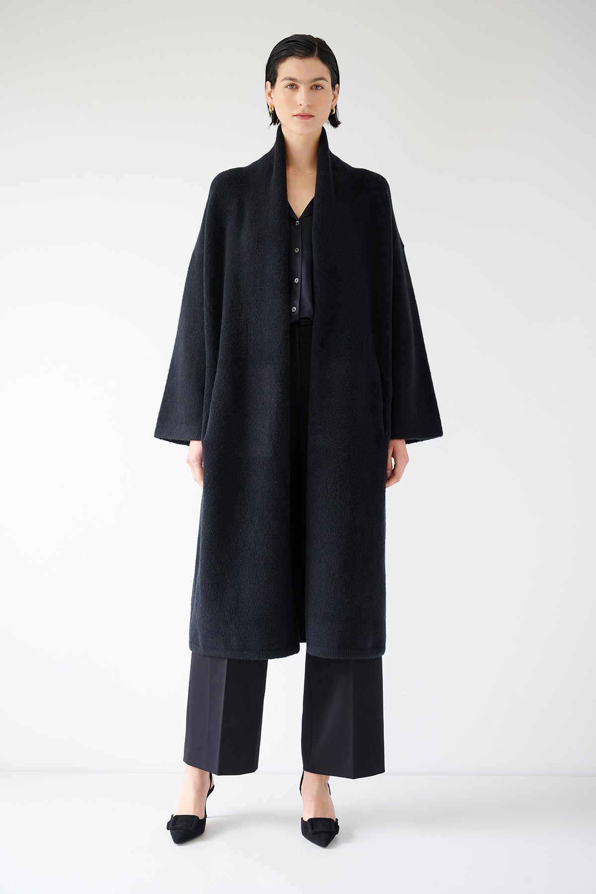 A woman donning a black Carmel Coat by Velvet by Jenny Graham and wool pants.-35547930329281