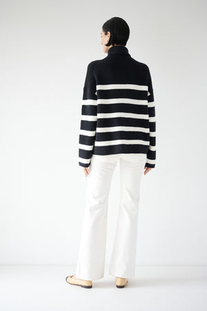 The back view of a woman wearing an oversized ENCINO SWEATER in a black and white striped pattern, by Velvet by Jenny Graham.