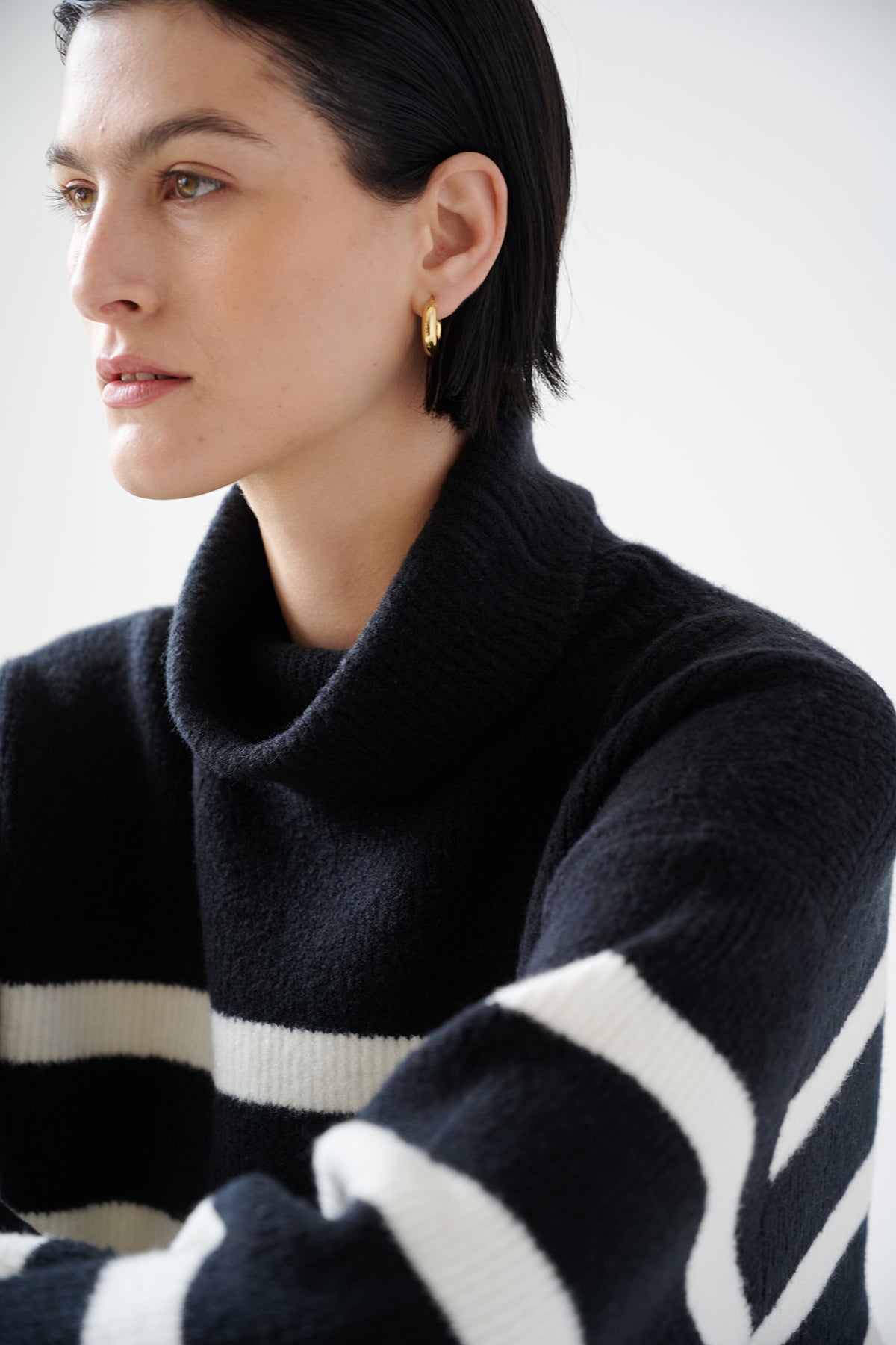   A woman wearing an oversized and cozy ENCINO SWEATER by Velvet by Jenny Graham, a wool blend turtleneck sweater. 