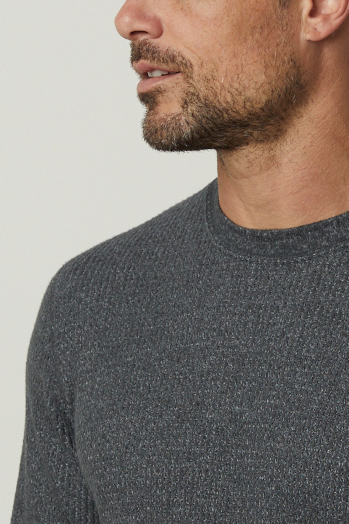 A man wearing a grey Velvet by Graham & Spencer sweater, perfect for cooler days, in a crew neck style made with premium thermal knit.-35547551629505