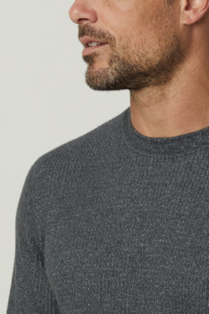 A man wearing a grey Velvet by Graham & Spencer sweater, perfect for cooler days, in a crew neck style made with premium thermal knit.