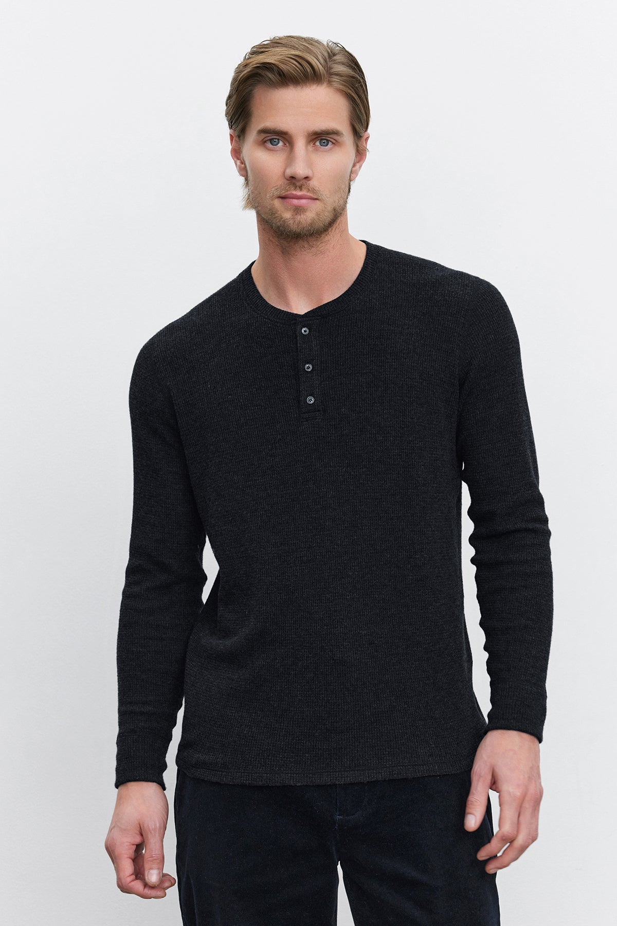 A man with short hair stands against a plain white background, wearing the AMBROSE HENLEY from Velvet by Graham & Spencer. This triblend cozy thermal fabric henley features a three-button placket.-37893849055425