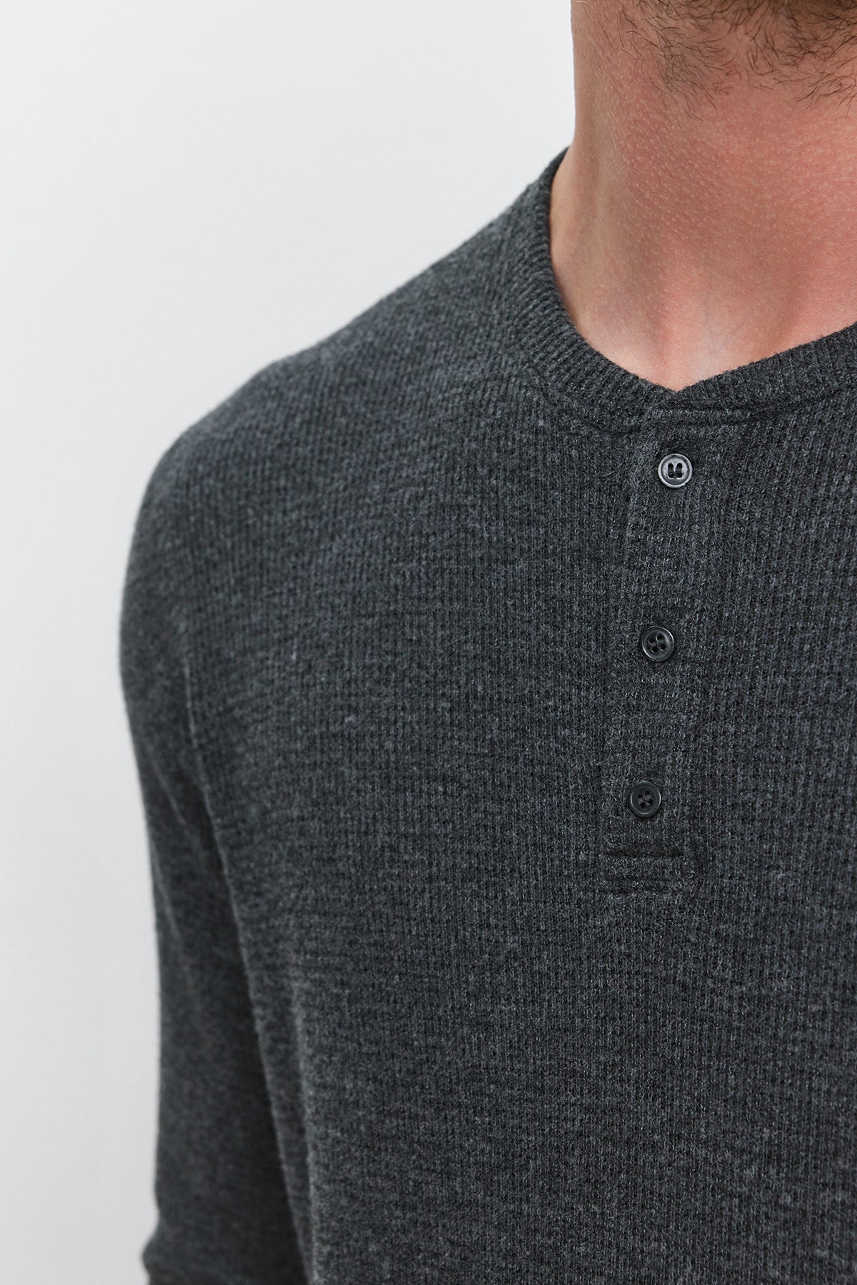 Close-up view of a person wearing Velvet by Graham & Spencer's AMBROSE HENLEY in dark gray triblend cozy thermal fabric with a three-button placket; only the neck and upper chest are visible against a plain background.-37893849252033