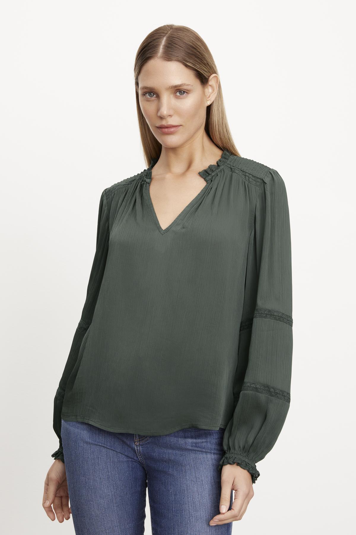   The model is wearing a green lace Velvet by Graham & Spencer blouse with long sleeves. 