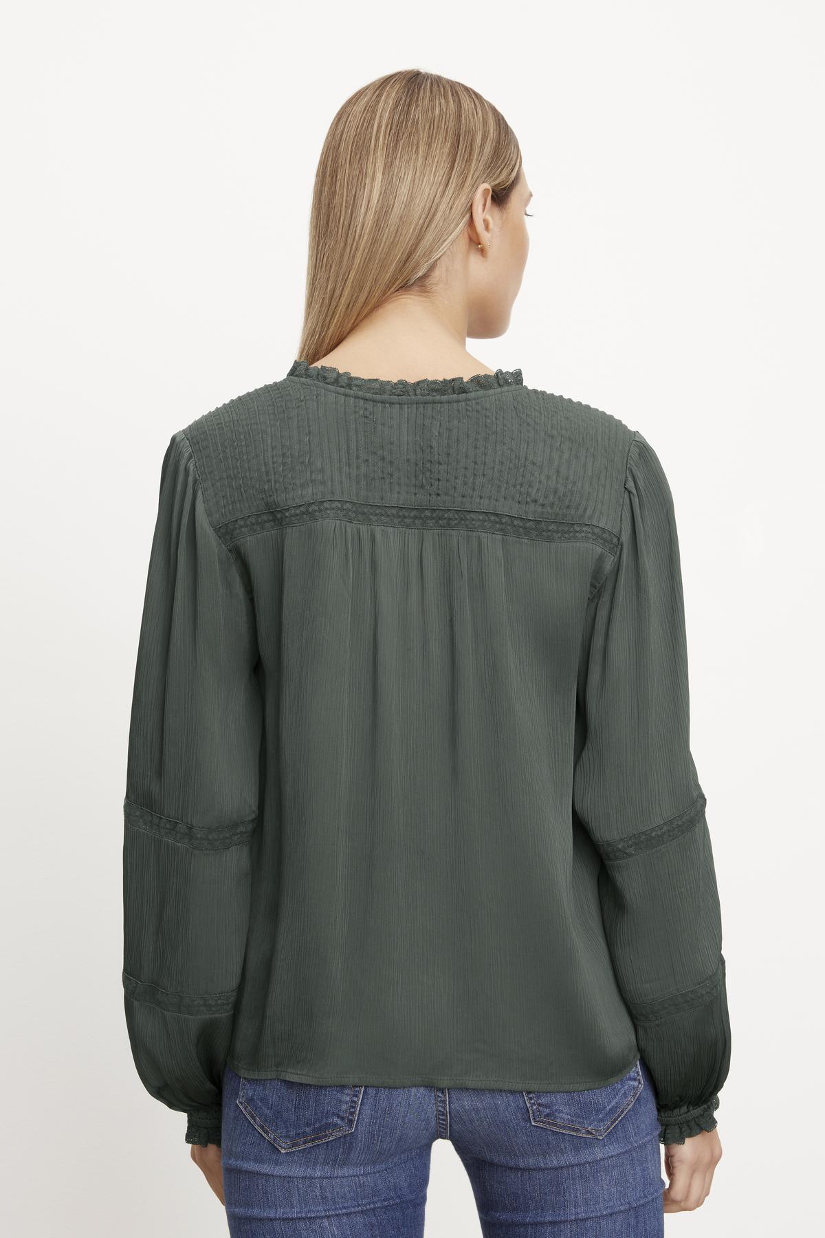 The back view of a woman wearing jeans and a Velvet by Graham & Spencer Koren V-Neck Blouse.-35630355382465