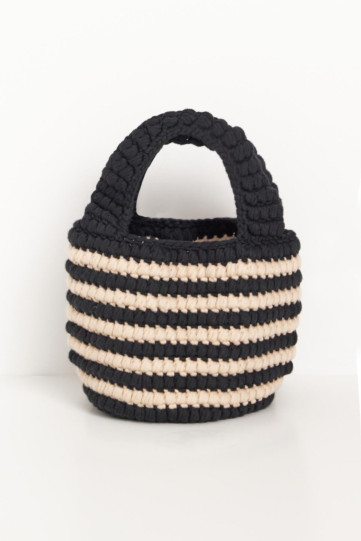   A handmade KNOX BAG crochet knit bag with alternating black and beige stripes, featuring a sturdy loop handle, displayed against a white background. Brand Name: Velvet by Jenny Graham 