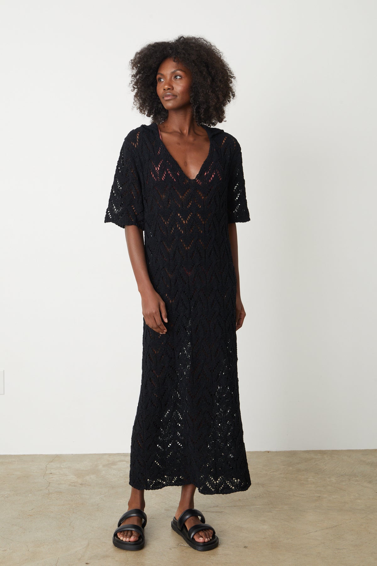   A woman wearing the Velvet by Graham & Spencer Jacqueline Crochet Stitch Maxi Dress and sandals. 