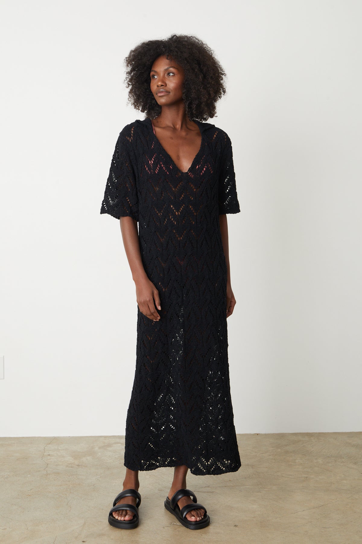 A woman wearing the Velvet by Graham & Spencer Jacqueline Crochet Stitch Maxi Dress and sandals.-35204869521601