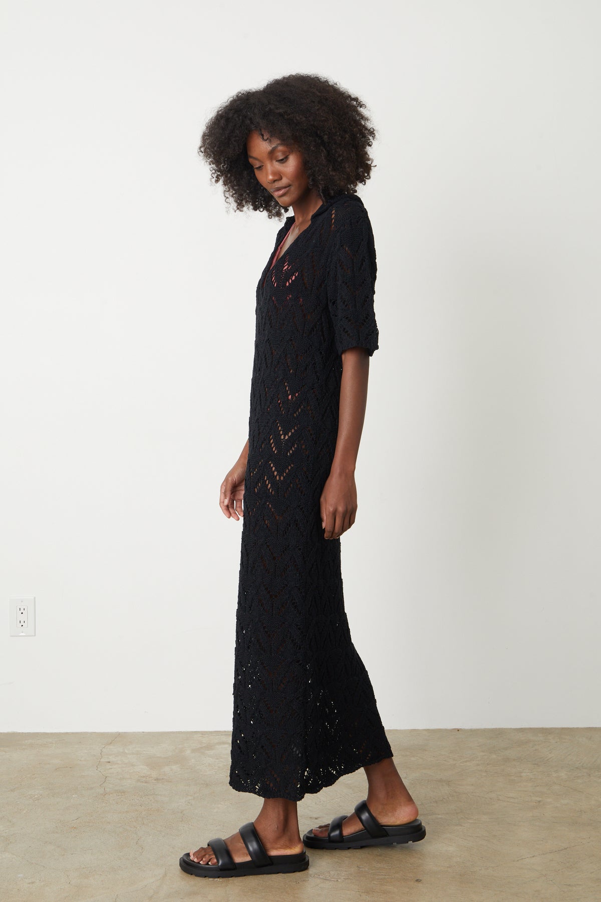  A woman wearing a Velvet by Graham & Spencer Jacqueline Crochet Stitch Maxi Dress and sandals. 
