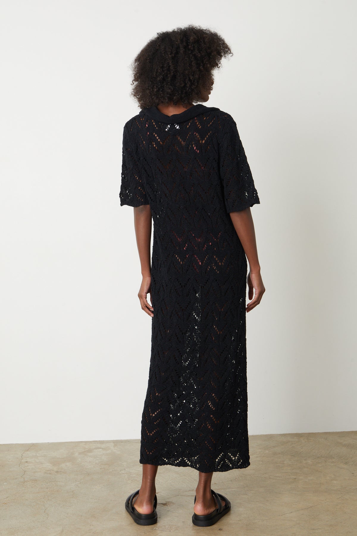 The back view of a woman wearing a Velvet by Graham & Spencer JACQUELINE CROCHET STITCH MAXI DRESS.-35204869587137