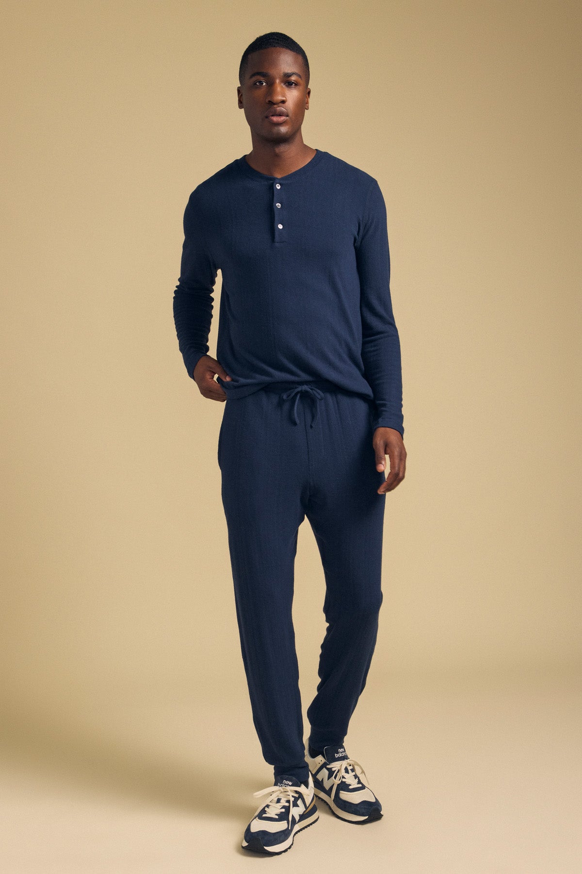 A man wearing a navy long-sleeve henley shirt and matching navy ELLIS SWEATPANT lounge pants with a drawstring waist.