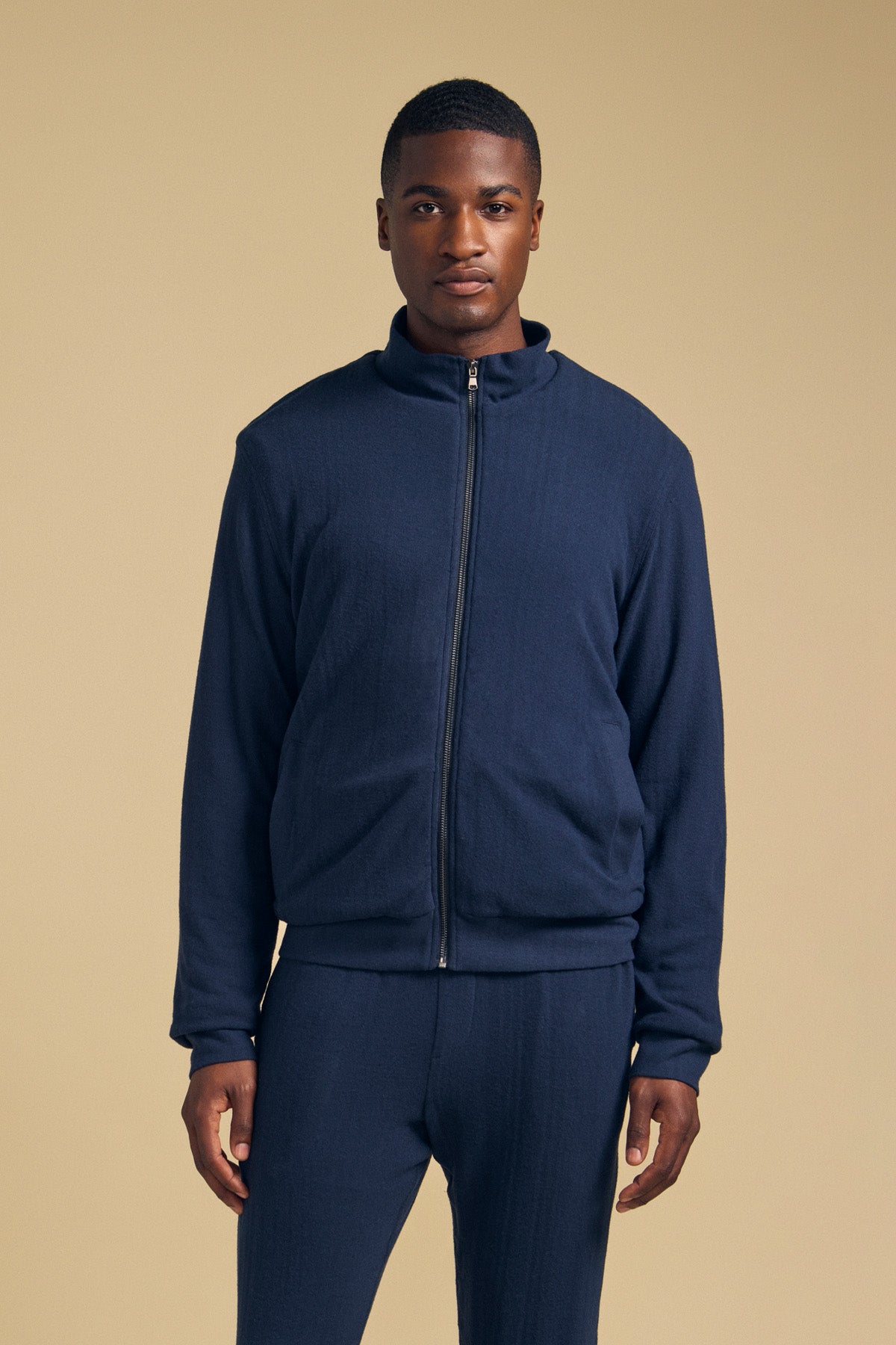 A man wearing a navy blue Velvet by Graham & Spencer NASH JACKET, a full-zip style with a mock neck collar.-46288273211585