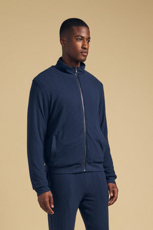 A man wearing a cozy NASH JACKET full-zip jersey and matching joggers with neutral-toned sneakers.
