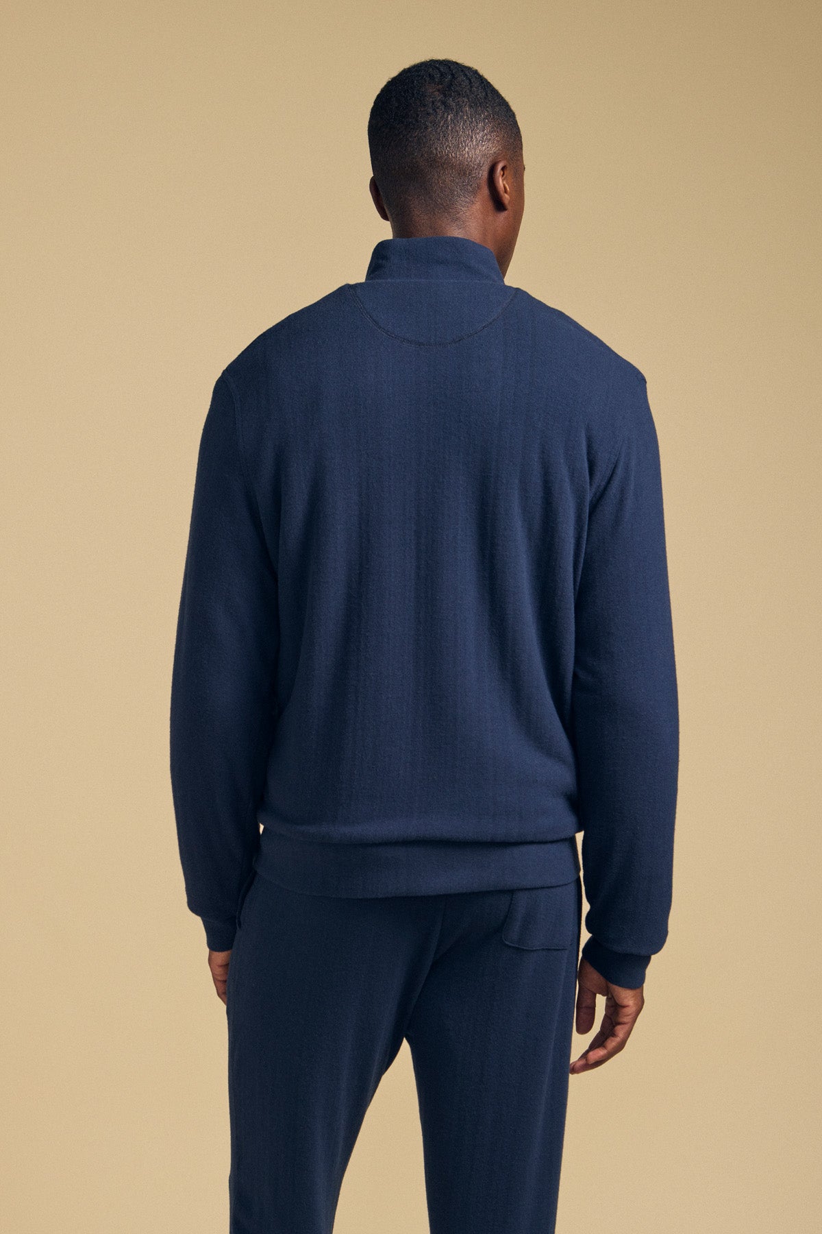 Back view of a person wearing a navy blue Velvet by Graham & Spencer NASH JACKET with a mock neck and matching pants.