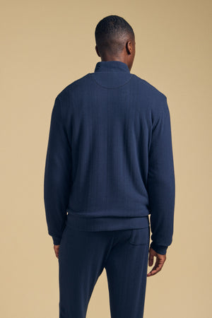 Back view of a person wearing a navy blue Velvet by Graham & Spencer NASH JACKET with a mock neck and matching pants.