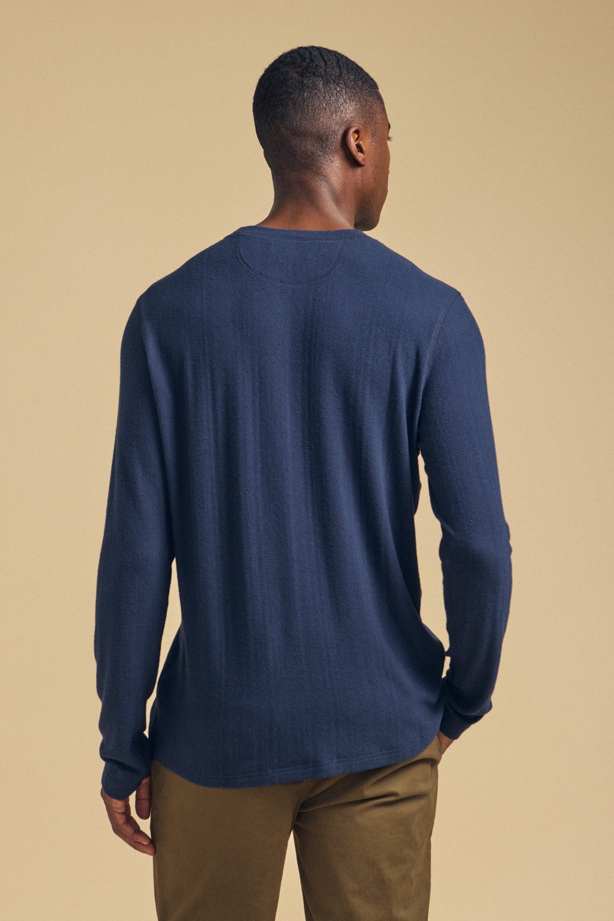 A man seen from behind wearing a navy REDDEN CREW PULLOVER.
